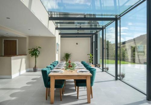 a dining room with a long table and green chairs at Secluded Luxury Off-Grid Hideaway in Selkirk