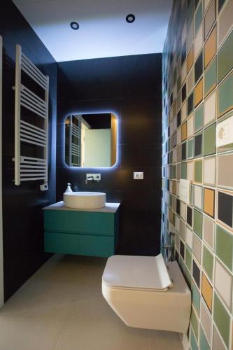 a bathroom with a sink and a toilet and a mirror at Vila Luarasi Blue Apartment in Kaninë