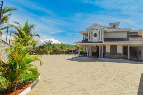 a building with a courtyard in front of it at Rock Hyrax Hotel in Nakuru