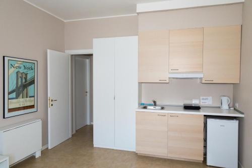 a kitchen with white cabinets and a sink at Appartamenti Leonardo in Rho