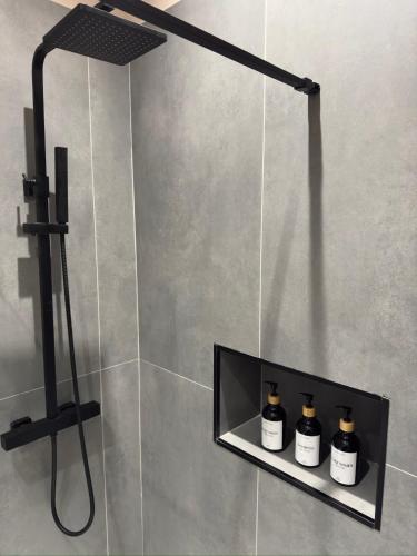 a shower with three bottles on a shelf in a bathroom at Bonheur Luxury Rooms in Ercolano