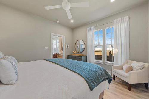 a bedroom with a bed and a chair and a mirror at Gloria Cottage - 2 blocks to Magnolia and 3 mins to Baylor in Waco