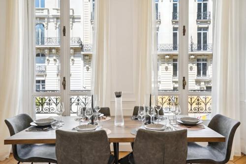 une salle à manger avec une table, des chaises et des fenêtres dans l'établissement 307-Suite Serbie - Superbe Appartement à Paris, à Paris