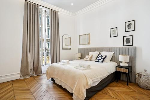 une chambre blanche avec un lit et une fenêtre dans l'établissement 307-Suite Serbie - Superbe Appartement à Paris, à Paris