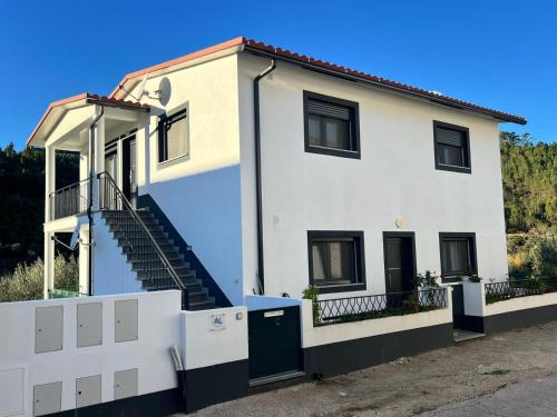 a white house with a staircase in front of it at Alojamentos da Aldeia in Vila de Rei