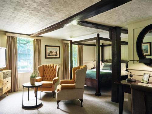 Un dormitorio con una cama y una mesa y sillas. en The Talbot Inn, en Woking