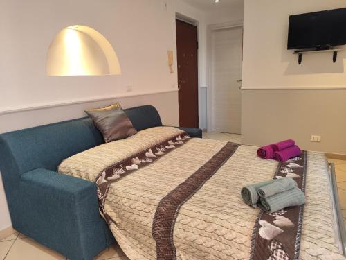 a bedroom with a bed and a blue couch at Casa Ludovica Centocelle in Rome