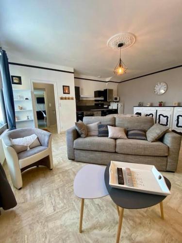 un salon avec un canapé et une table dans l'établissement Gites L etape conviviale, à Guitté