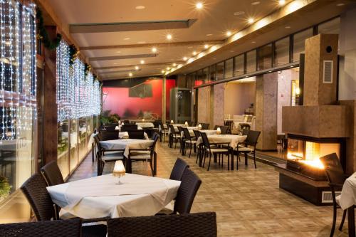 a restaurant with tables and chairs and a fireplace at City Palace Hotel in Ohrid