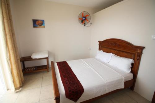 a bedroom with a bed with a wooden headboard at Villas Vetiver in Rodrigues Island