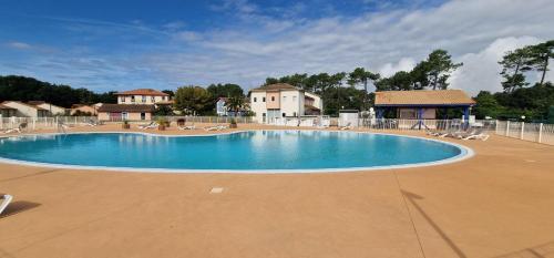 - une grande piscine dans un complexe avec des chaises longues dans l'établissement Villa Maëlyssia - Les villas du lac, à Soustons