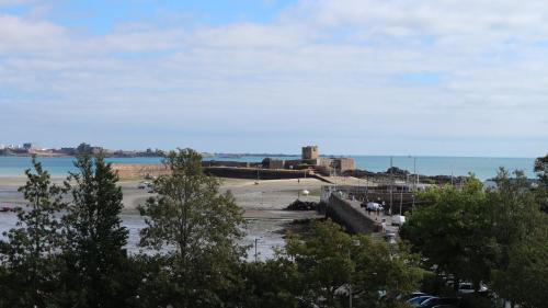 a view of a beach with trees and the water at Peterborough House in Saint Aubin