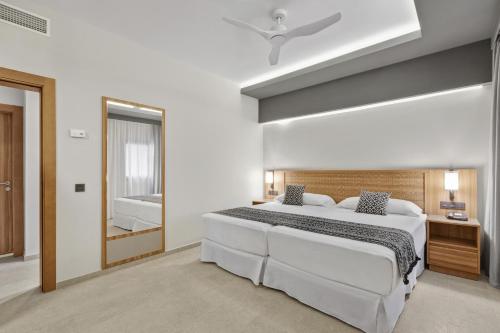 a bedroom with a large white bed and a bathroom at Hotel Riu Palace Santa Maria - All Inclusive in Santa Maria