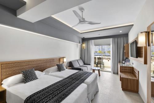 a hotel room with a bed and a living room at Hotel Riu Palace Santa Maria - All Inclusive in Santa Maria