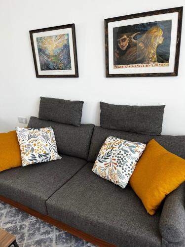 a gray couch with pillows in a living room at Retreat, Block A1, unit 6 in Küçükerenköy
