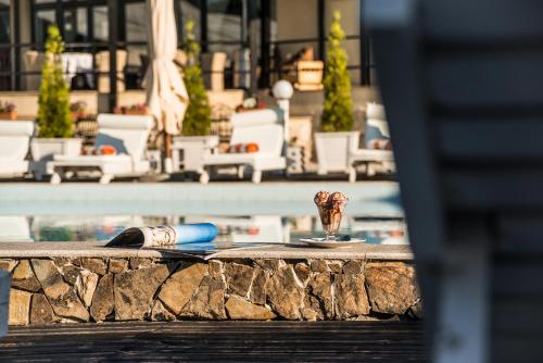 a swimming pool with a table and a glass of wine at Conacul Archia in Deva