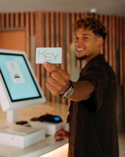 a man holding a piece of paper in front of a computer at NEXT - by Savoy Signature in Funchal