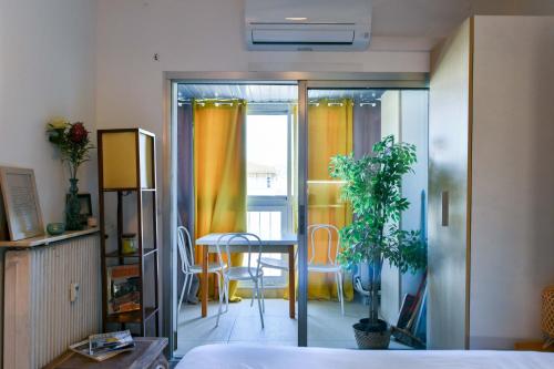 une chambre avec un lit, une table et des chaises dans l'établissement LE FESTIF splendide studio avec loggia au Carré d'Or, une joie spéciale pour deux, à Cannes