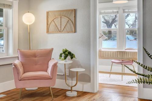 a living room with a pink chair and a table at Institute Aura! Family Home w Quiet Workspace in Colorado Springs