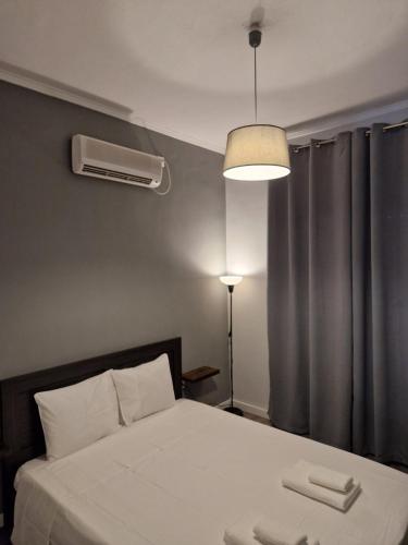 ein Schlafzimmer mit einem weißen Bett und einem Fenster in der Unterkunft MP Studios in Artemida