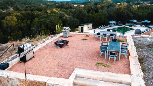 an outdoor patio with a grill and tables and chairs at Starlight Horizon Cabin M - Pet-Friendly Texas Hill Country Cabin Near Canyon Lake - Pool, Stargazing & Group Getaways - Sleeps 8 in Canyon Lake
