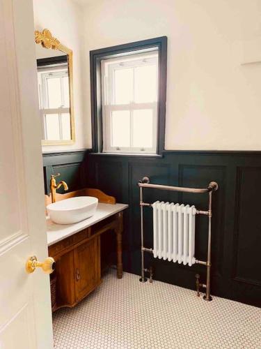 a bathroom with a sink and a mirror and a sink at Edwardian house by the seaside in Porthcawl
