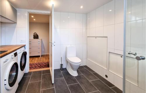 a bathroom with a toilet and a washing machine at Lovely Home In Göteborg With Kitchen in Gothenburg