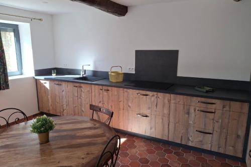 - une cuisine avec une table en bois et un évier dans l'établissement La maison d'Antoine à Robion, à Robion