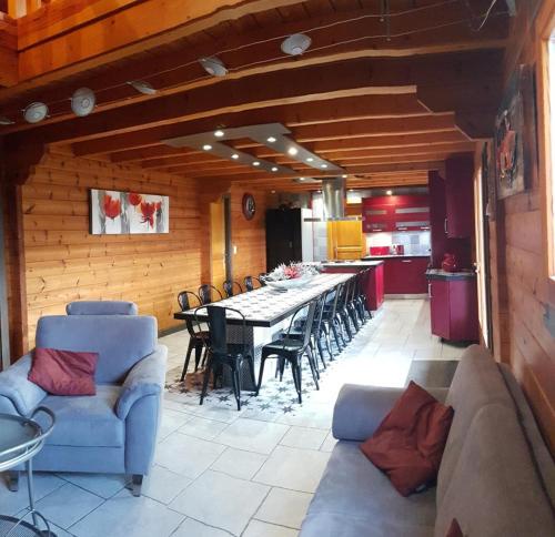 une salle à manger avec une longue table et des chaises dans l'établissement Chalet Maya, Belle vue lac, Sauna, SPA et Wifi, à Gérardmer