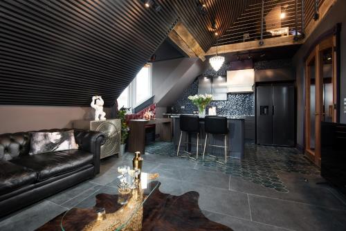 a living room with a leather couch and a bar at NYC Loft, Luxury Apartment in Berwick-Upon-Tweed