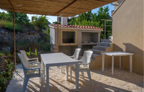 a patio with a table and chairs and a fireplace at Cozy Apartment In Zlarin With Wifi in Zlarin