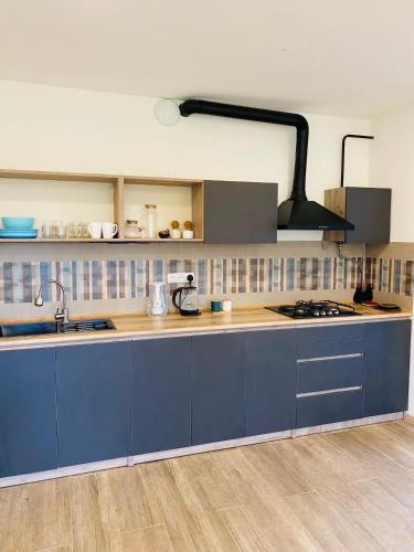 a kitchen with blue cabinets and a stove top oven at Dez Guest House, Margahovit, Lori in Margahovit
