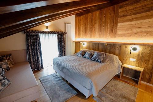 a bedroom with a bed in a room with wooden walls at La Caso Di Elva in Elva