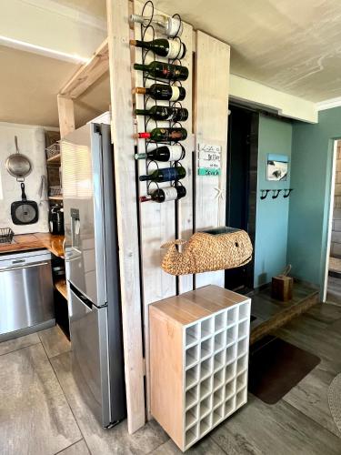 a kitchen with a rack of wine bottles at Seaview on 2822 Happy Whale Cottage in Bettyʼs Bay