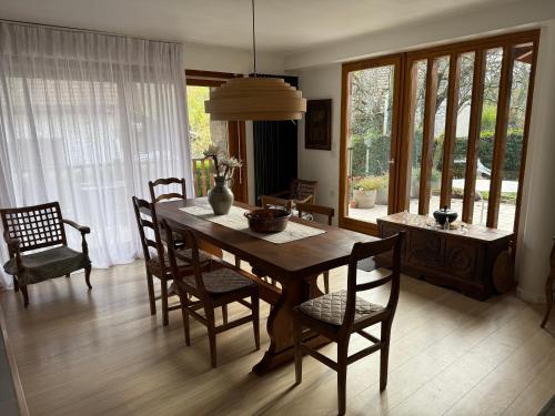 une salle à manger avec une table et des chaises en bois dans l'établissement La grange à Philibert, à Cusy