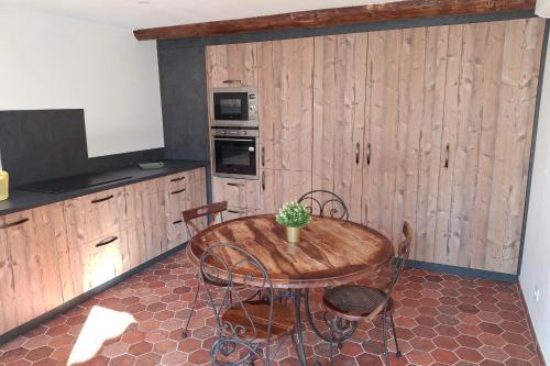 une cuisine avec une table et des chaises en bois et une table sidx sidx sidx dans l'établissement La maison d'Antoine à Robion, à Robion