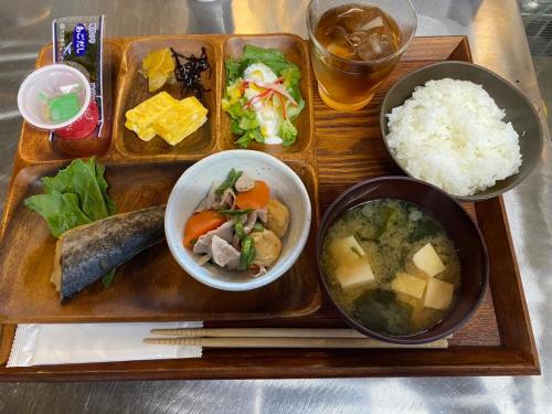 a tray of food with bowls of food and rice at LOGINNtarassoログインタラソ沖永良部島 in Wadomari