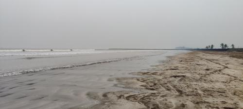 an empty beach with footprints in the sand at Home stay at Anant Villa Chaul Alibag Near Nagav Beach in Alibag