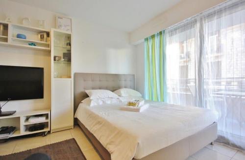 une chambre avec un grand lit et une télévision dans l'établissement Le Palais de Med Studio Promenade des Anglais, à Nice