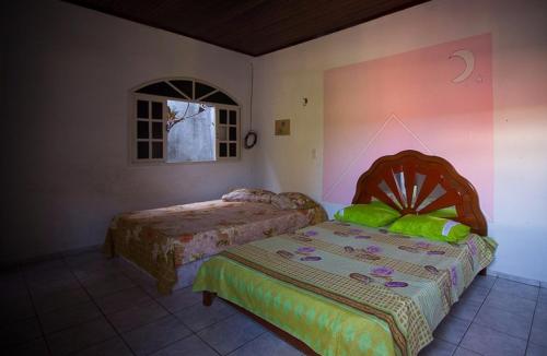 una camera da letto con due letti e una finestra di Casa aconchegante a Natal