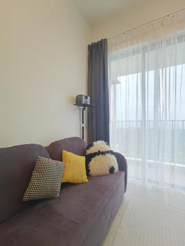 a living room with a brown couch with pillows and a window at Super Comfort 2R2B Luxury Seaview Sandakan in Sandakan