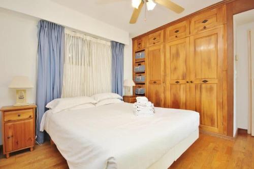 - une chambre avec un grand lit blanc et des placards en bois dans l'établissement Le Palais de Med - 2 bedrooms, à Nice