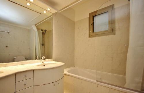 une salle de bain avec un lavabo, une baignoire et un miroir dans l'établissement Le Palais de Med - 2 bedrooms, à Nice