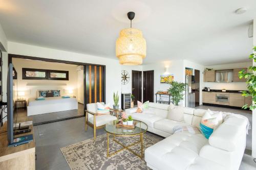 a living room with a white couch and a table at Indigo Garden at Blue Bay Golf & Beach Resort in Willemstad