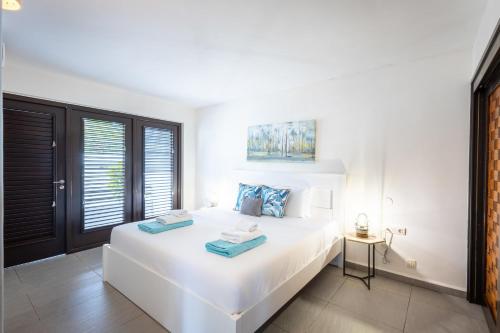 a bedroom with a white bed with blue towels on it at Indigo Garden at Blue Bay Golf & Beach Resort in Willemstad