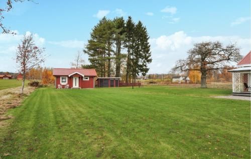 a small red house in a field with a green yard at 1 Bedroom Amazing Home In Kristinehamn in Edet