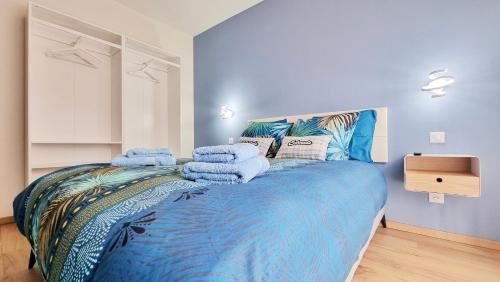 a bedroom with a blue bed with towels on it at La grange d'Andre - Spa - 8 personnes - Proche Europa Park in Elsenheim