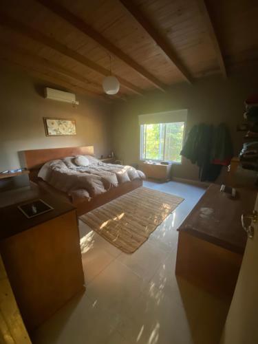 una grande camera da letto con un letto e una finestra di Linda casa a metros del río Paraná con pileta a Ituzaingó