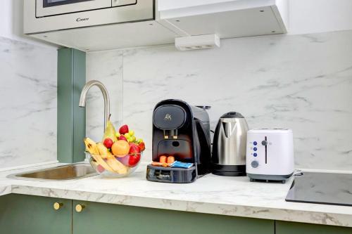 - un comptoir de cuisine avec un grille-pain et des fruits dans l'établissement 402 Suite Netter - Superbe Studio à Paris, à Paris