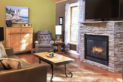 a living room with a fireplace with a tv at 2BR Cottage Surrounded by Nature in Tobermory